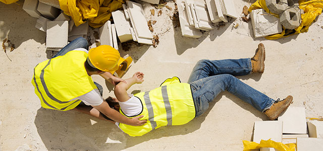 An injured construction worker on a construction site Image of two construction workers, one of whom is injured and will receive worker's compensation thanks to The Law Offices of Lawrence J. Signore in Providence, RI